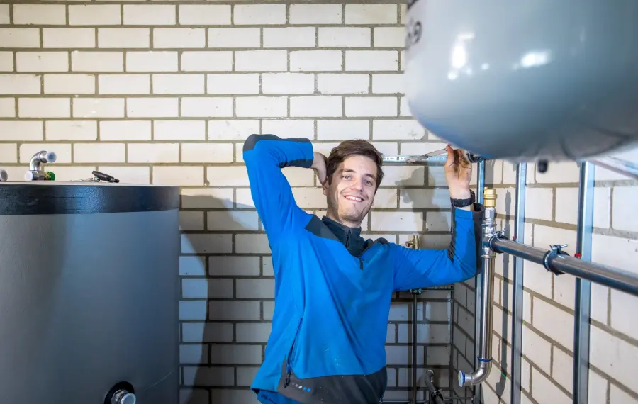 Monteur bij een expansievat en waterleidingen