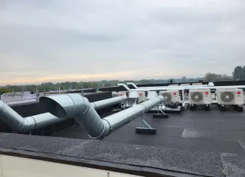Ventilatiekanalen en buitenunits op een bedrijfsdak