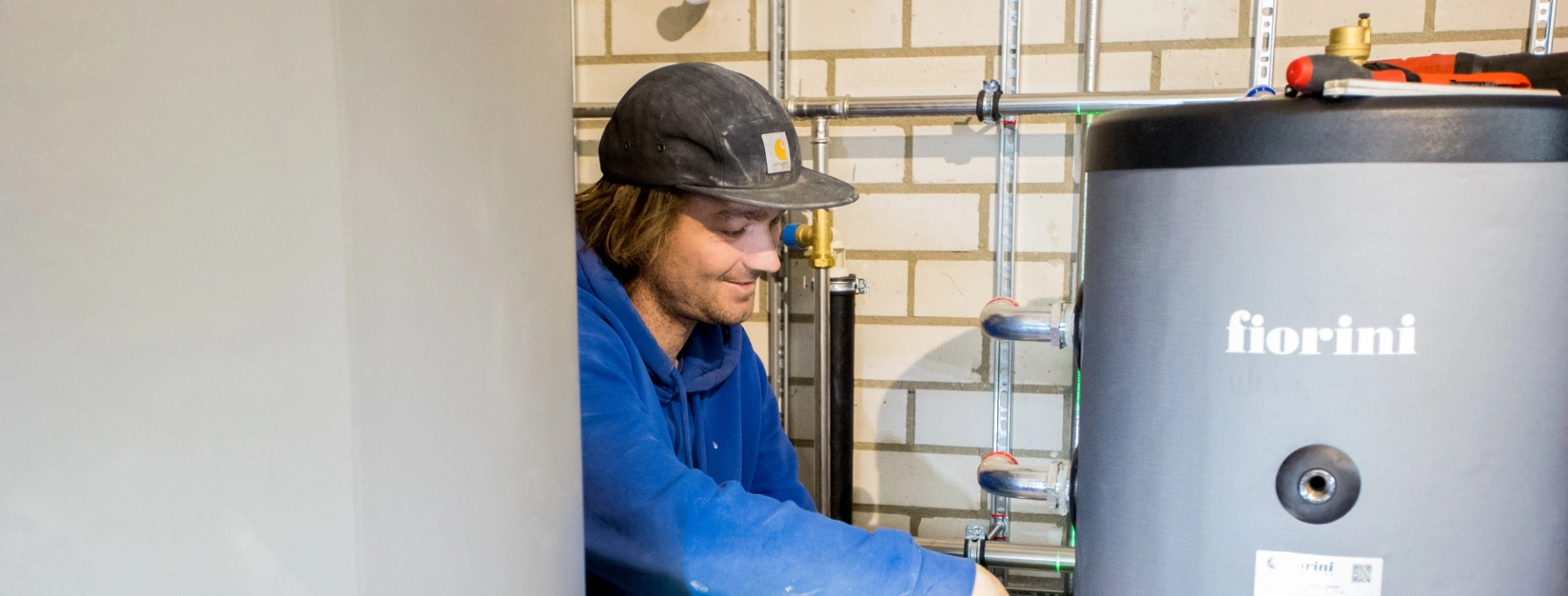 Monteur sluit een buffervat van een warmtepomp aan